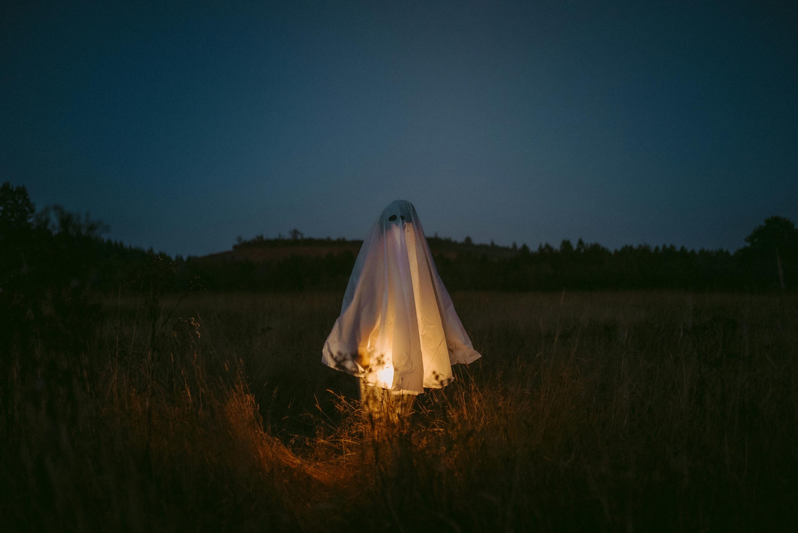 A ghostly figure illuminated in a dark field captures the Halloween spirit.